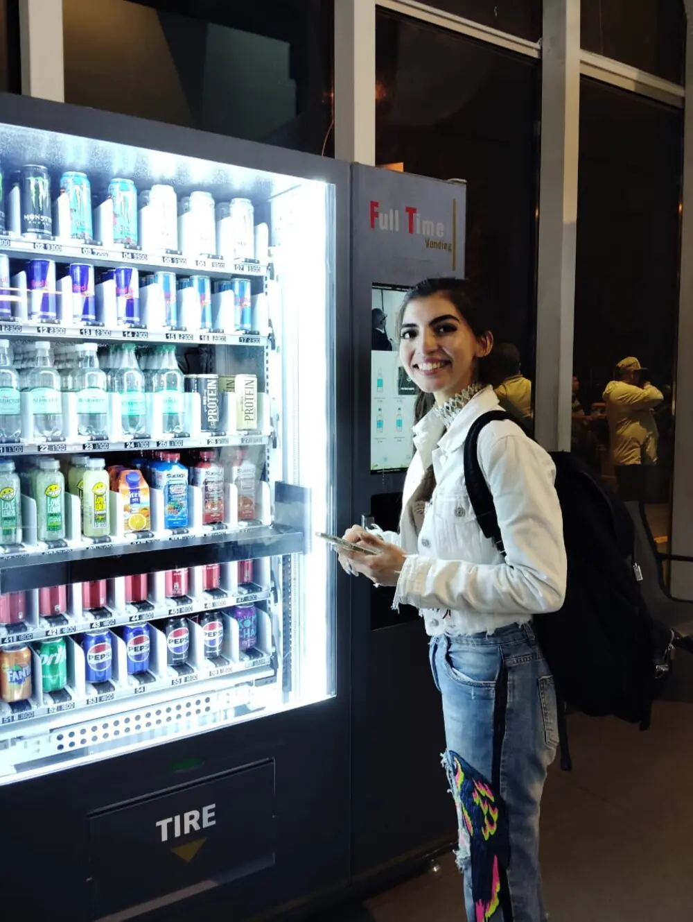 Clienta usando una máquina Full Time Vending iluminada de noche