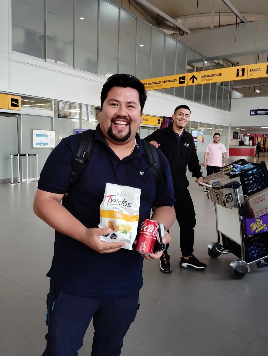 Colaborador Full Time Vending feliz con snacks y bebida en el aeropuerto
